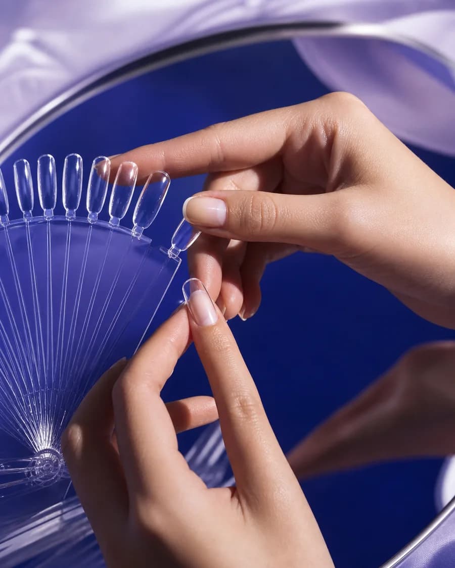 Two hands measuring a natural nail in a colourful GLAZEM studio